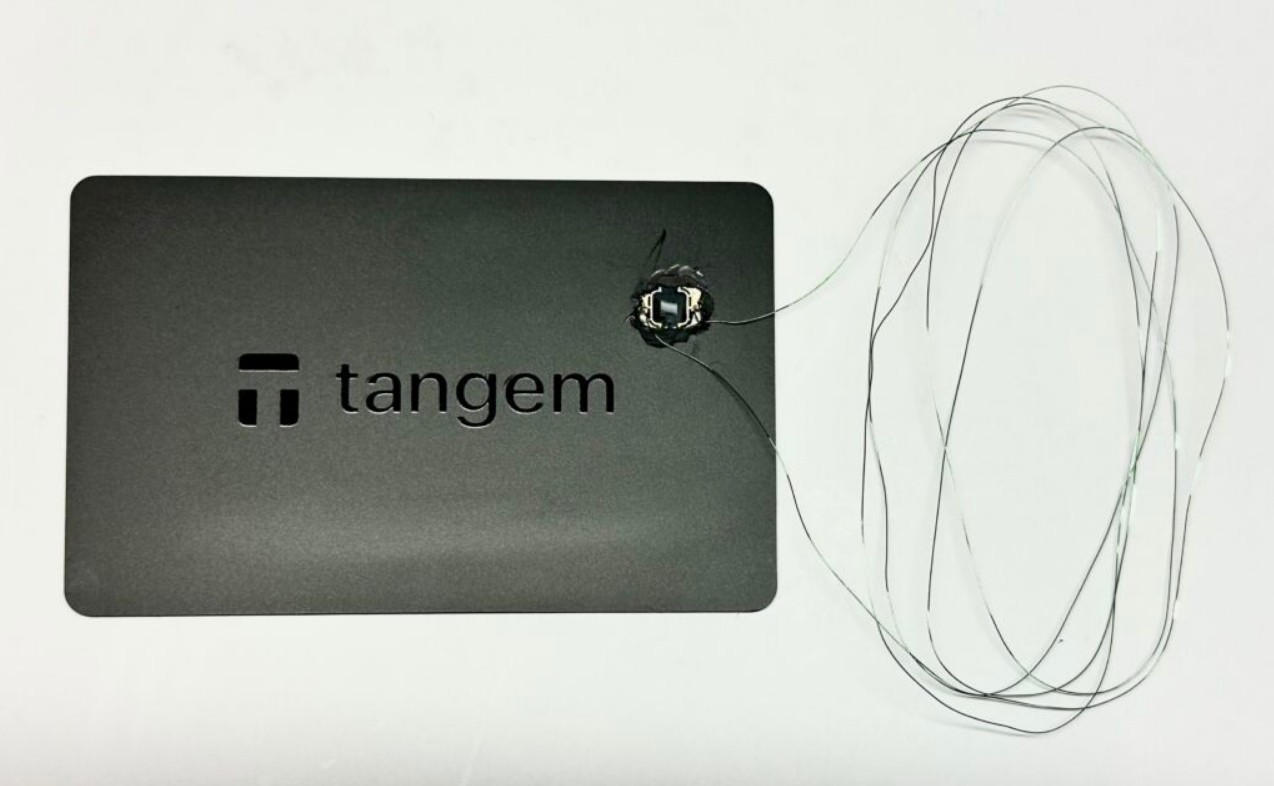 Cartão Tangem com a antena substituída por fios finos para medir o sinal eletromagnético do chip. Essa adaptação permite estudar como o chip processa comandos e testar possíveis vulnerabilidades de segurança. Fonte: Ledger.
